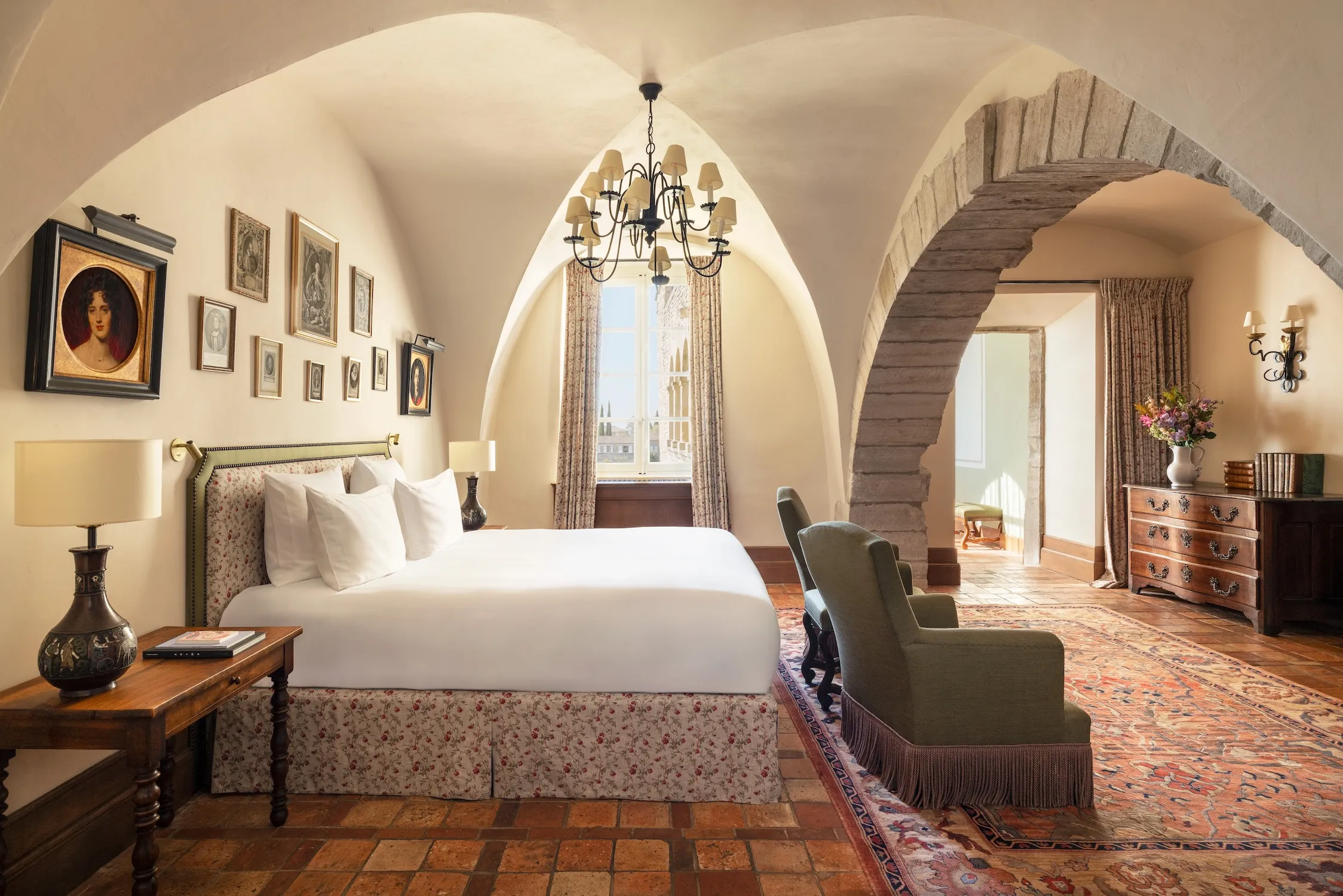 A guest room at La Bastide de Gordes furnished with antique pieces and views over the Luberon valley