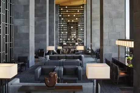 A suite interior at Aman Tokyo with a sunken living area, shoji screens and a low bed facing floor-to-ceiling windows