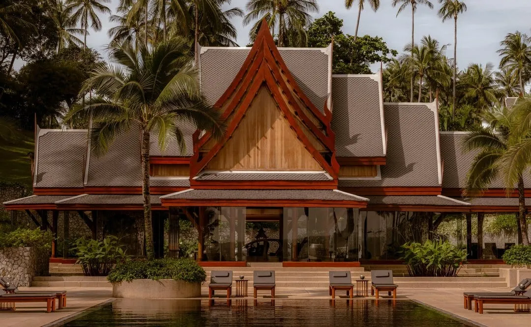Amanpuri's 27-metre midnight-blue main pool framed by coconut palms above Pansea Beach, Phuket