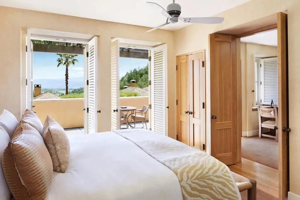 One of Auberge du Soleil's sun- and earth-toned guestrooms with French doors opening onto a private terrace overlooking the valley
