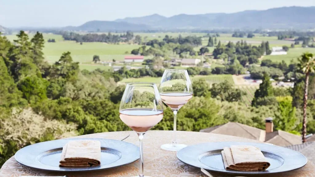 The dining terrace at The Restaurant at Auberge du Soleil, set for dinner with sweeping views across the Napa Valley floor