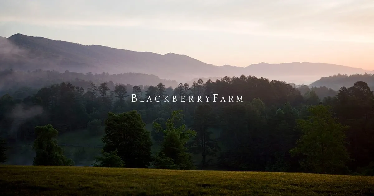 Rolling pastures and farm buildings of Blackberry Farm set against the foothills of the Great Smoky Mountains in Walland, Tennessee