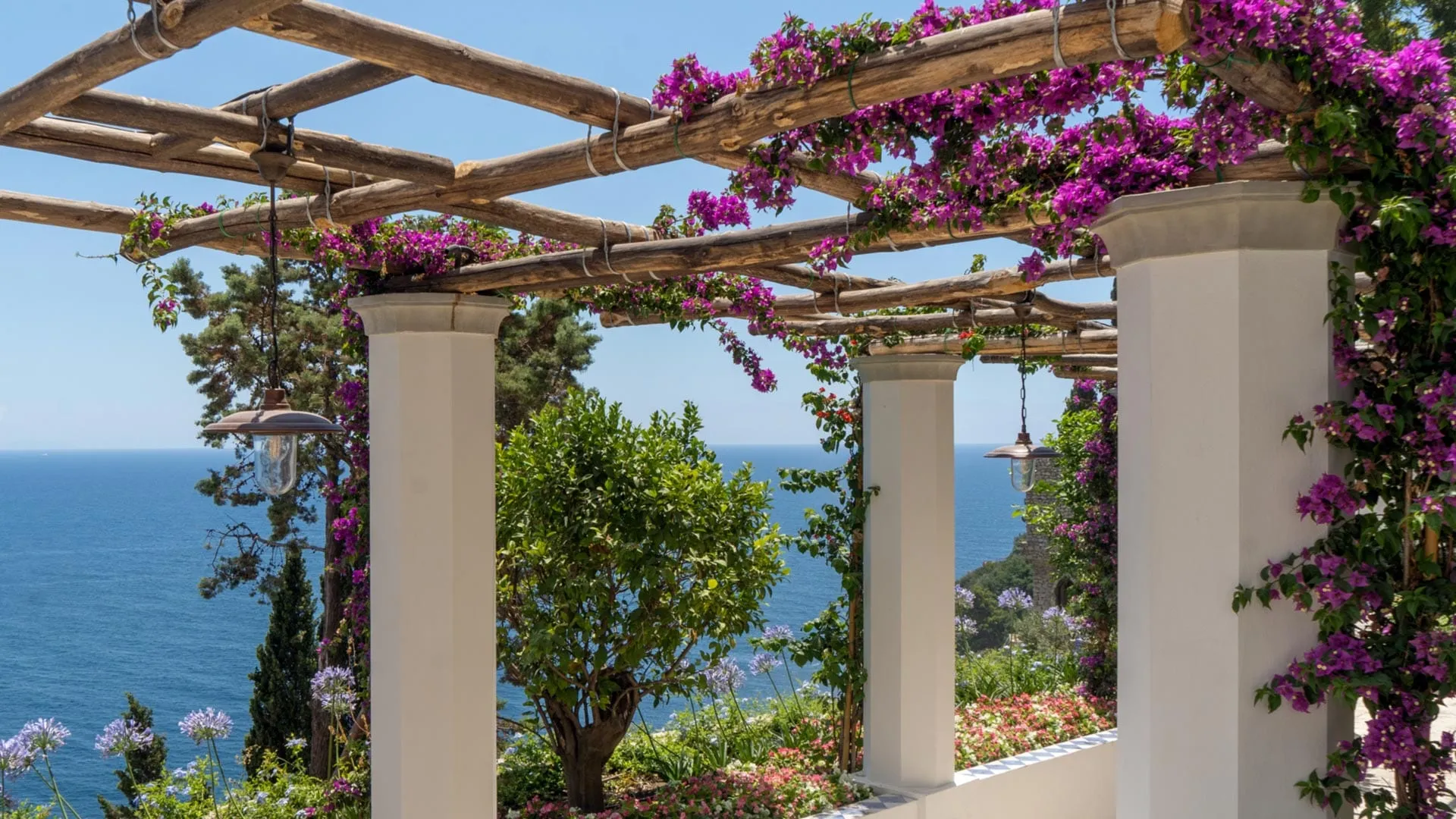 Terraced gardens and white-and-blue architecture stepping down the cliff at Borgo Santandrea