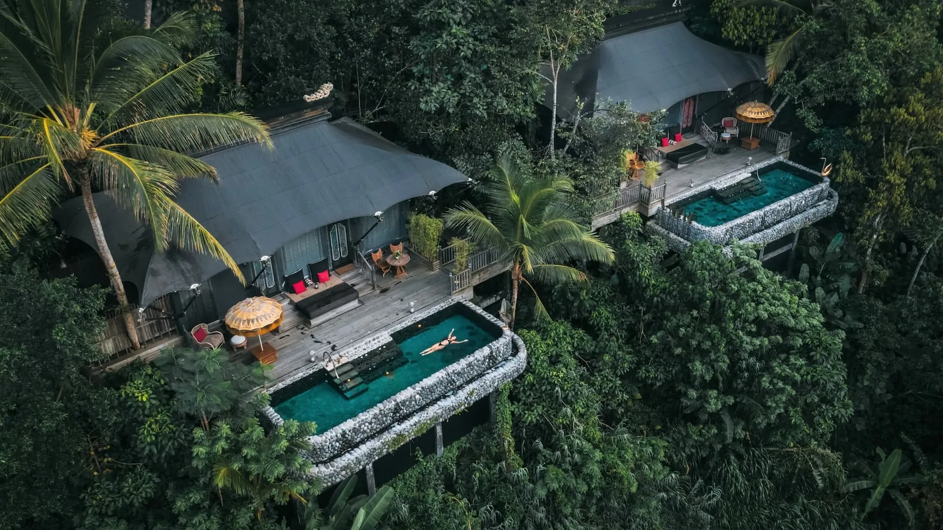 Aerial view of a tented pavilion and plunge pool at Capella Ubud surrounded by dense jungle