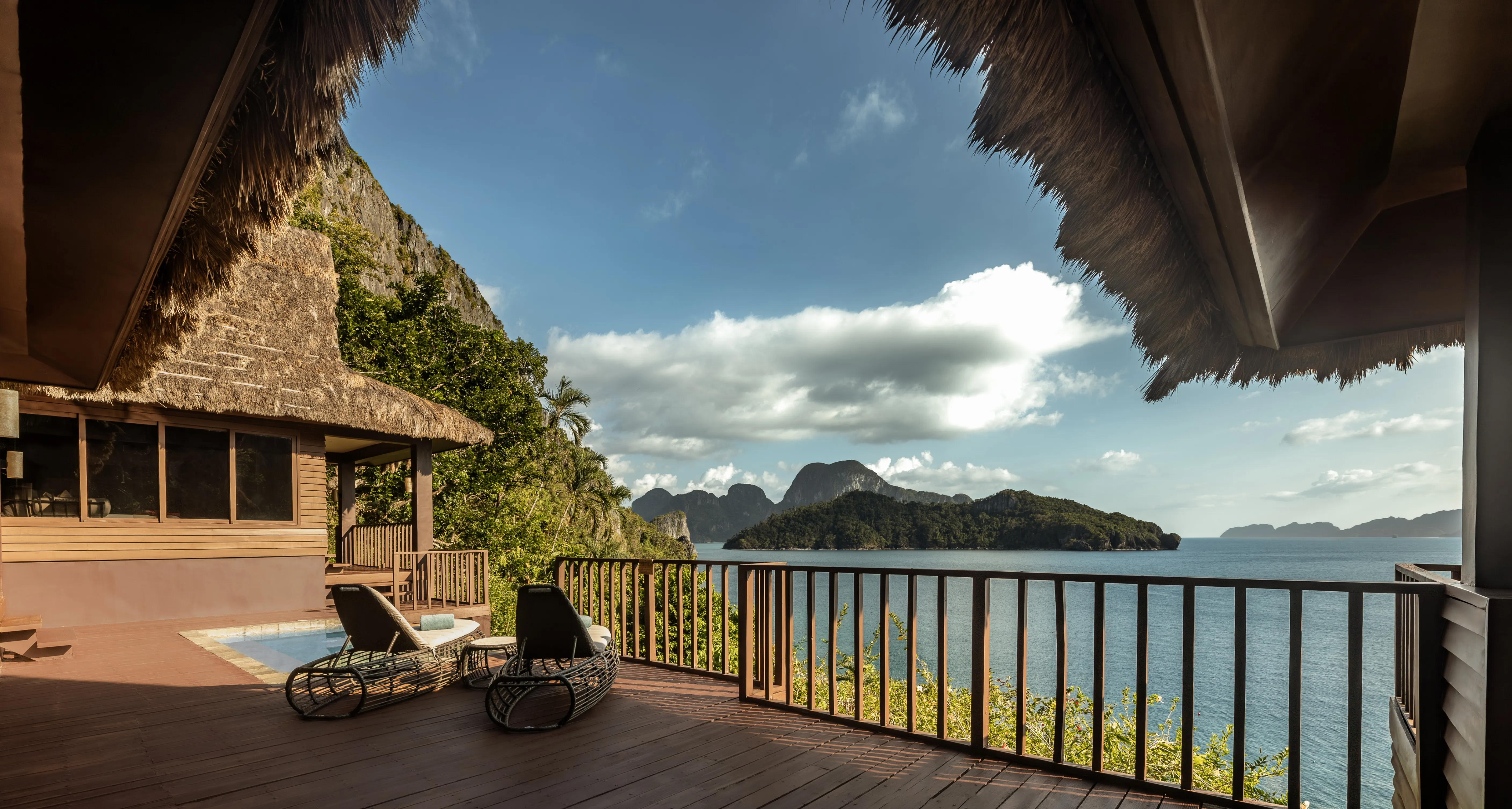 Overwater and beachfront villas at Cauayan Island Resort catching evening light across Bacuit Bay, El Nido