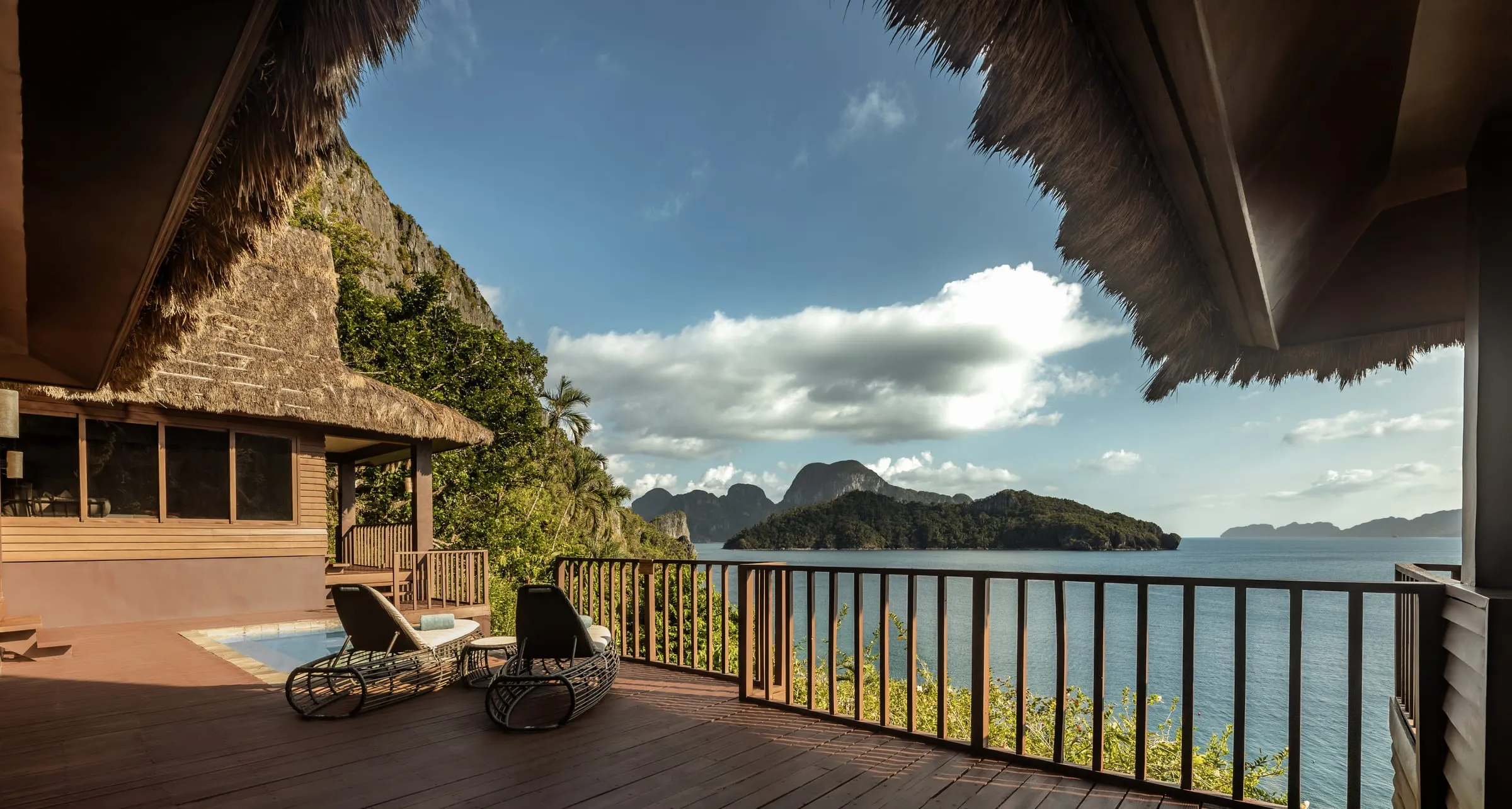 Overwater and beachfront villas at Cauayan Island Resort catching evening light across Bacuit Bay, El Nido