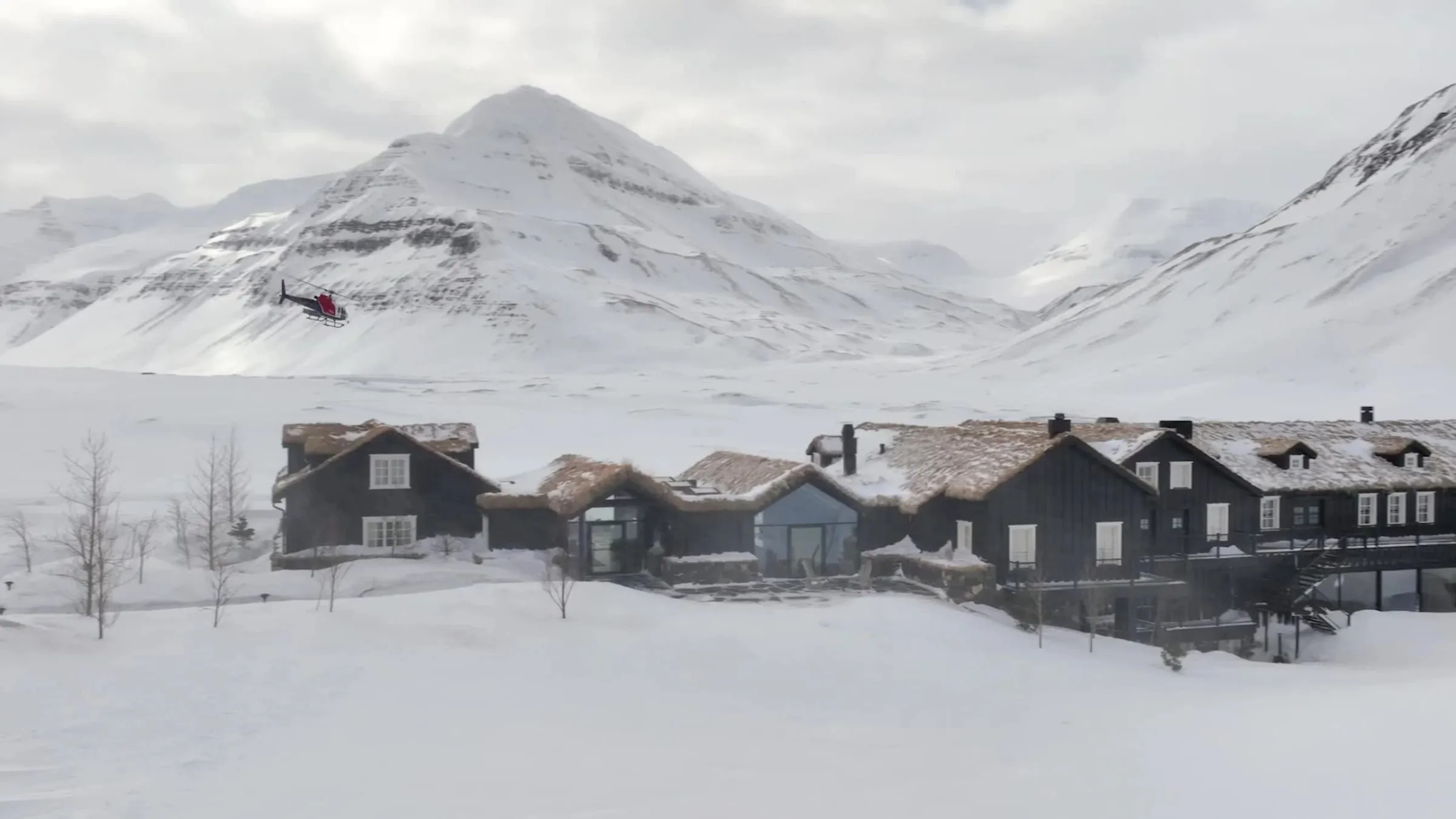 A turf-roofed lodge building at Deplar Farm set against the mountains of Iceland's Troll Peninsula