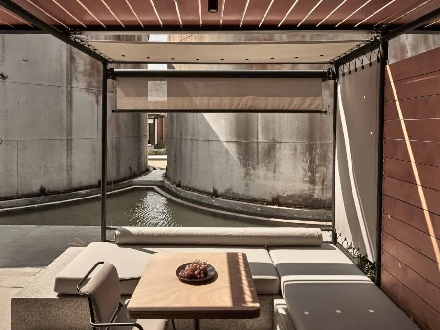 Interior detail of a suite at Dexamenes showing exposed concrete, timber and textured glass