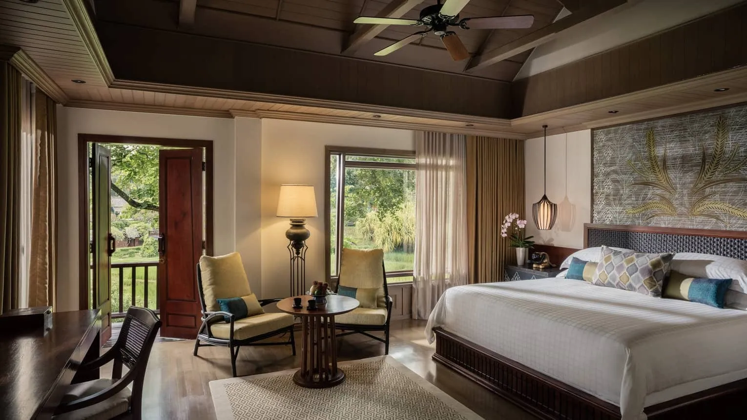Interior of a pavilion suite at Four Seasons Resort Chiang Mai with teak floors, Thai textiles and a private outdoor sala