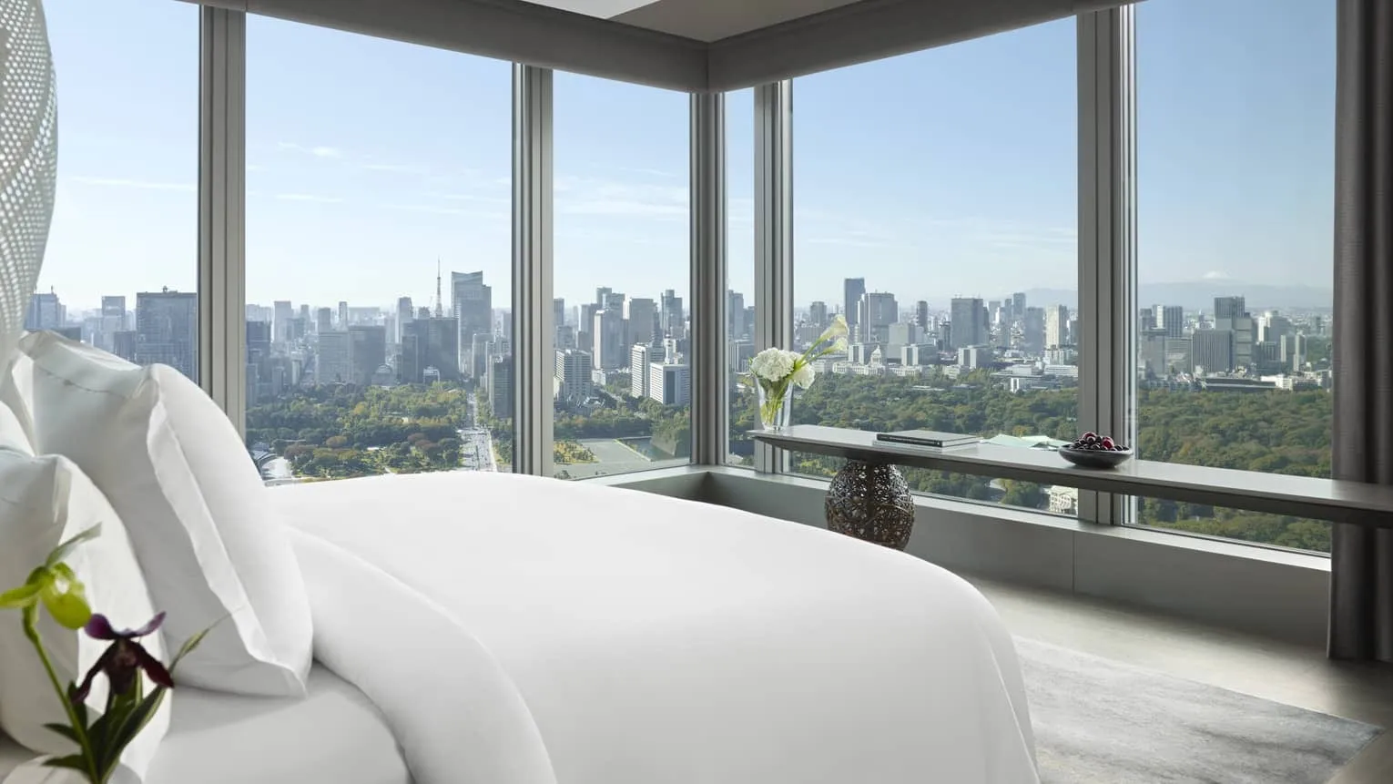 A guest room at Four Seasons Hotel Tokyo at Otemachi with floor-to-ceiling windows overlooking the Imperial Palace Gardens