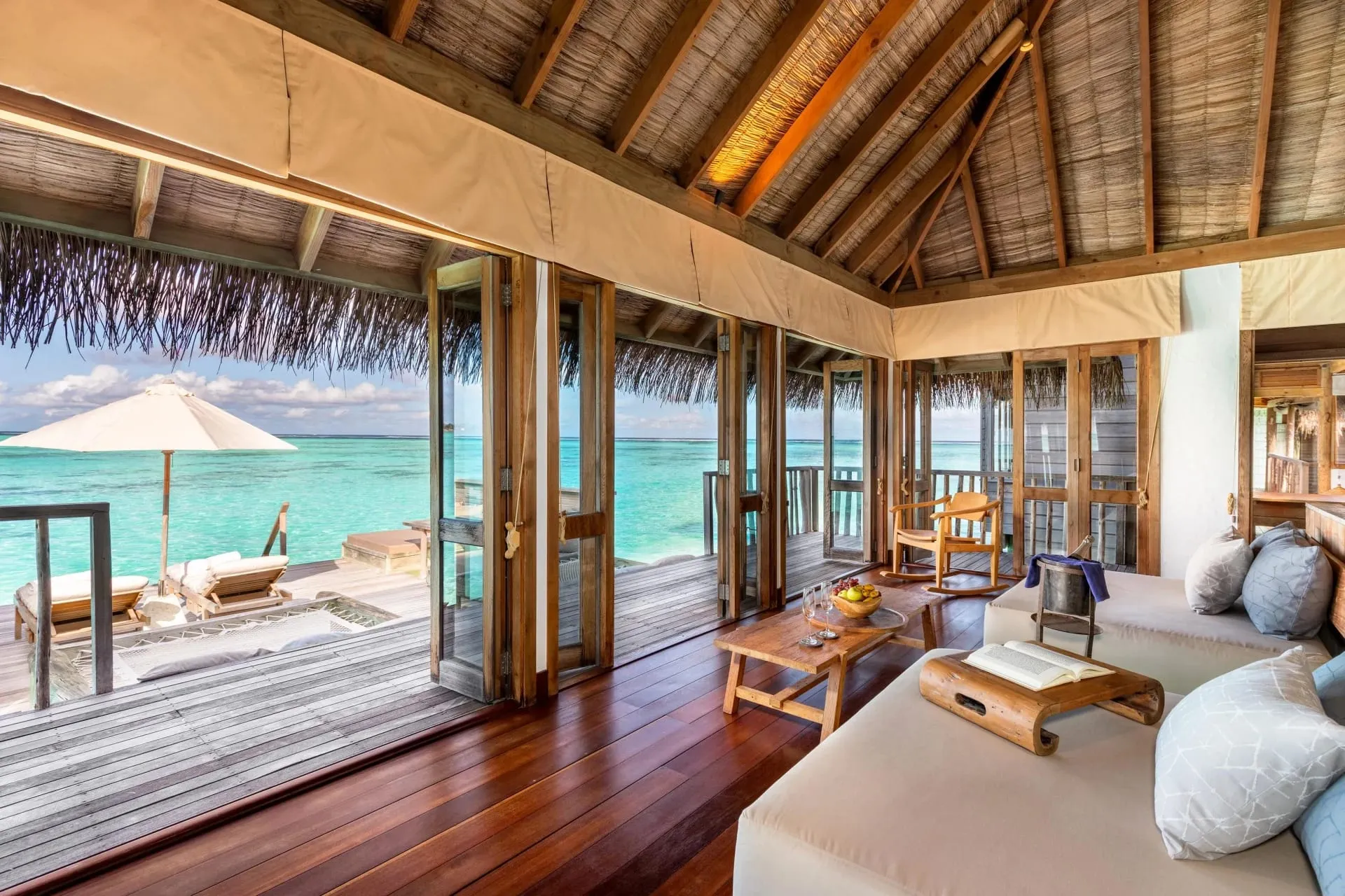 Timber walkway connecting overwater villas above a shallow turquoise lagoon at Gili Lankanfushi