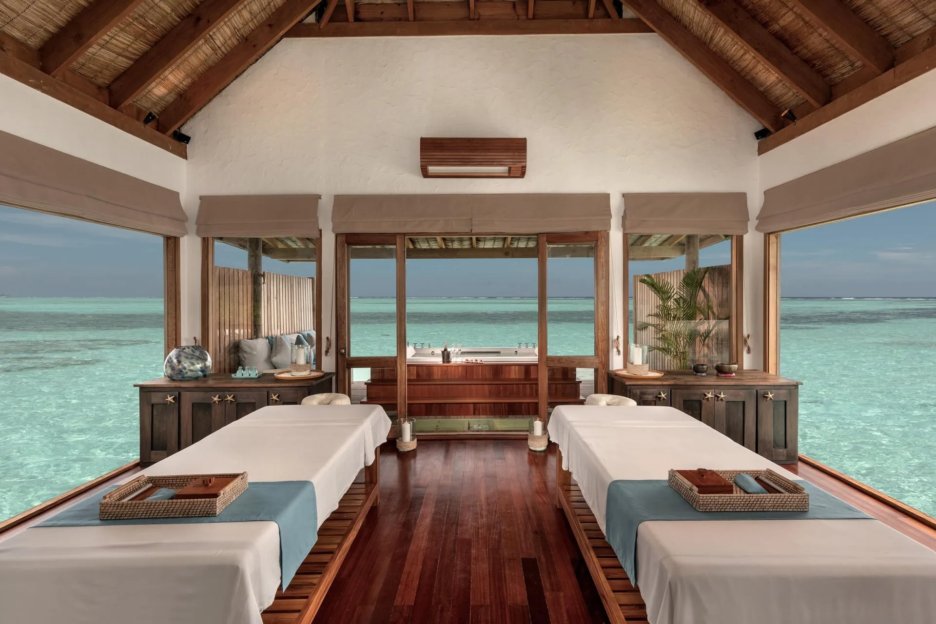 The Private Reserve villa's infinity pool and multi-level overwater deck at sunset