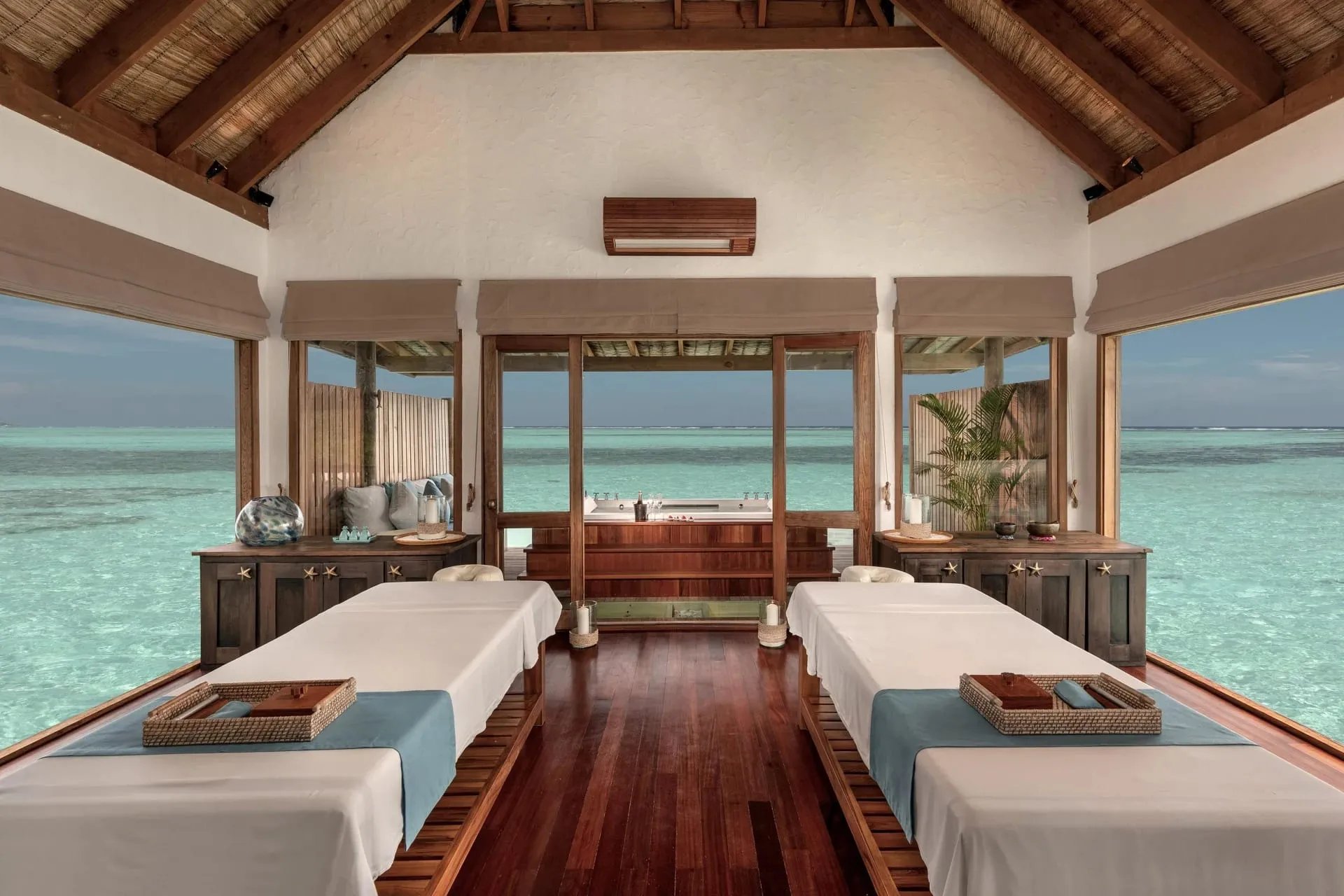 The Private Reserve villa's infinity pool and multi-level overwater deck at sunset