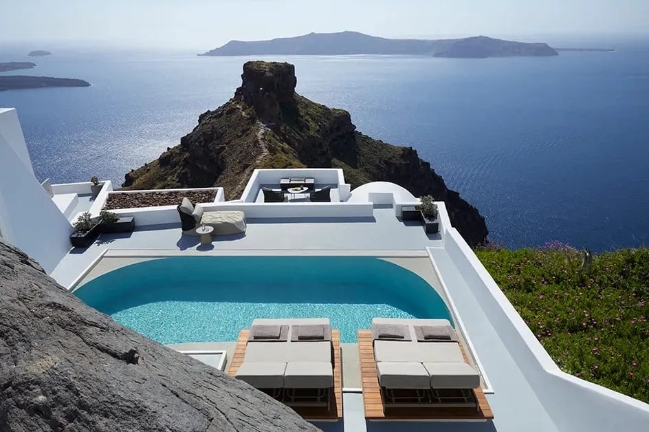Cubist white volumes carved into the cliff face at Grace Hotel Santorini