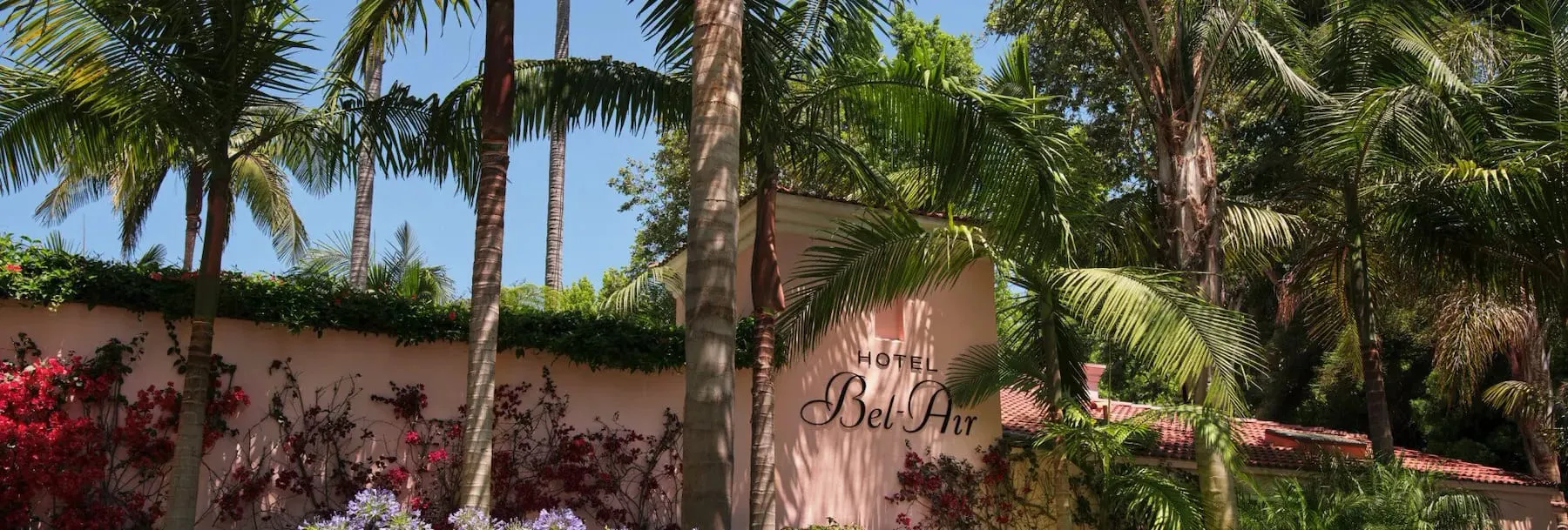 Hotel Bel-Air's rose-pink Mission Revival facade seen through twelve acres of mature gardens in Bel Air, Los Angeles