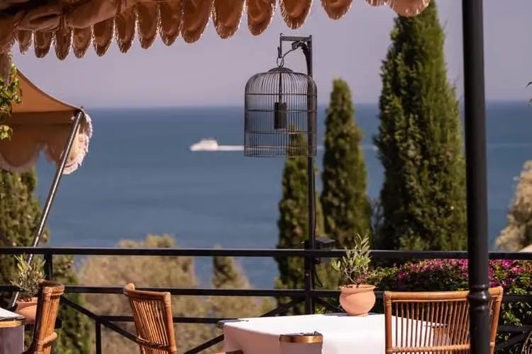 A terrace table set for dinner overlooking the Tyrrhenian Sea at Il Pellicano