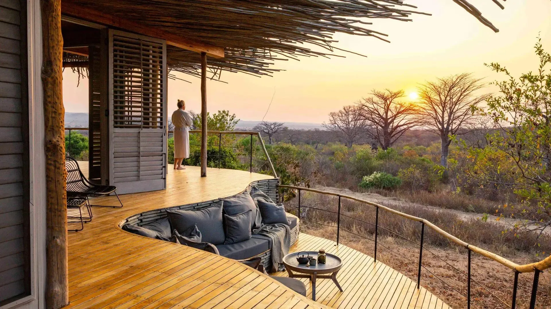 A suite interior at Jabali Ridge with a bed frame built from reclaimed dhow boat wood and slatted timber shutters