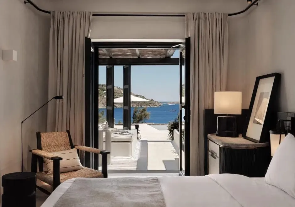 Whitewashed cubist volumes and stone pathways connecting the suites at Kalesma Mykonos