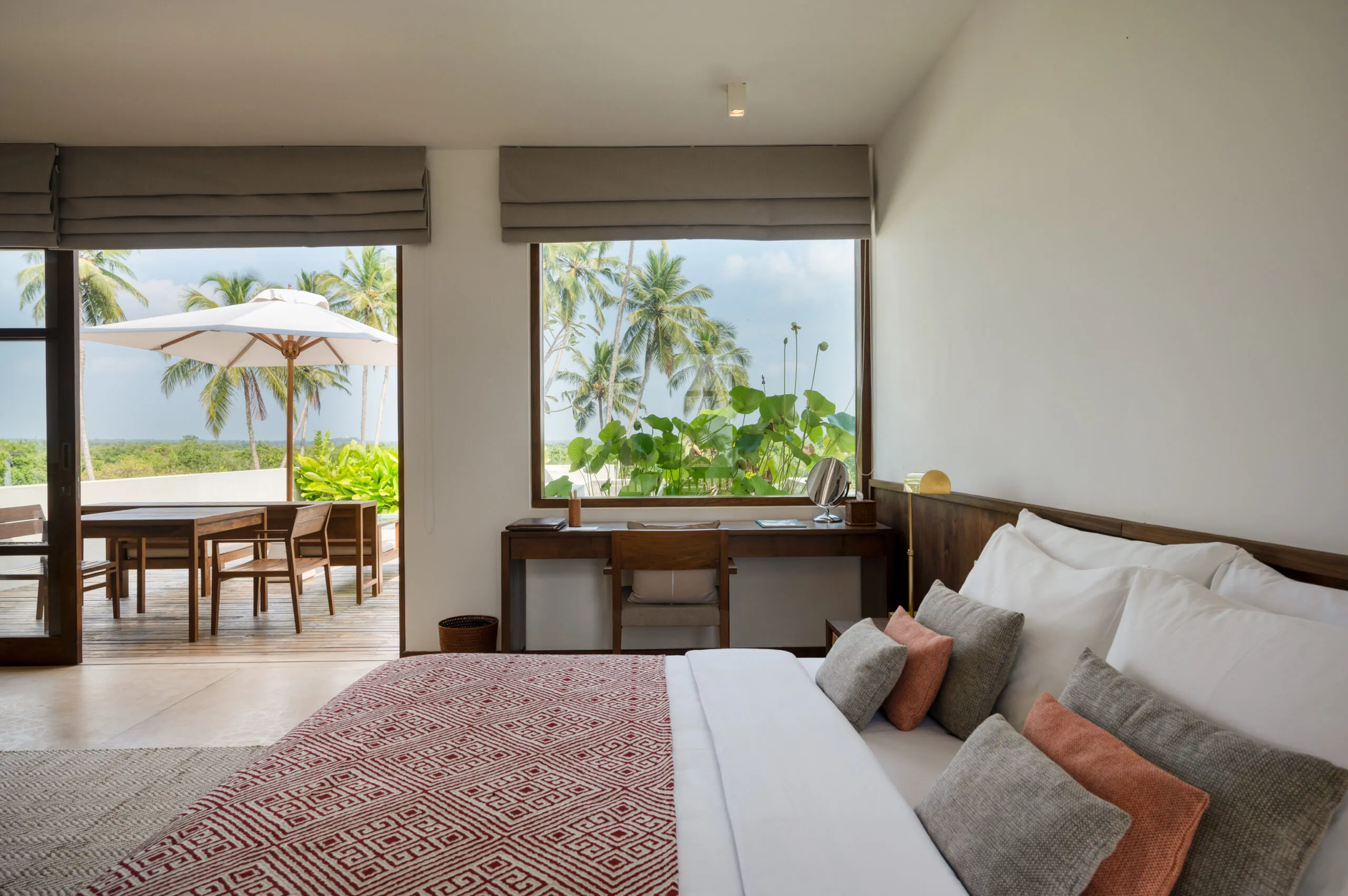 Far-reaching infinity pool flanked by frangipani and coconut palms at Kayaam House