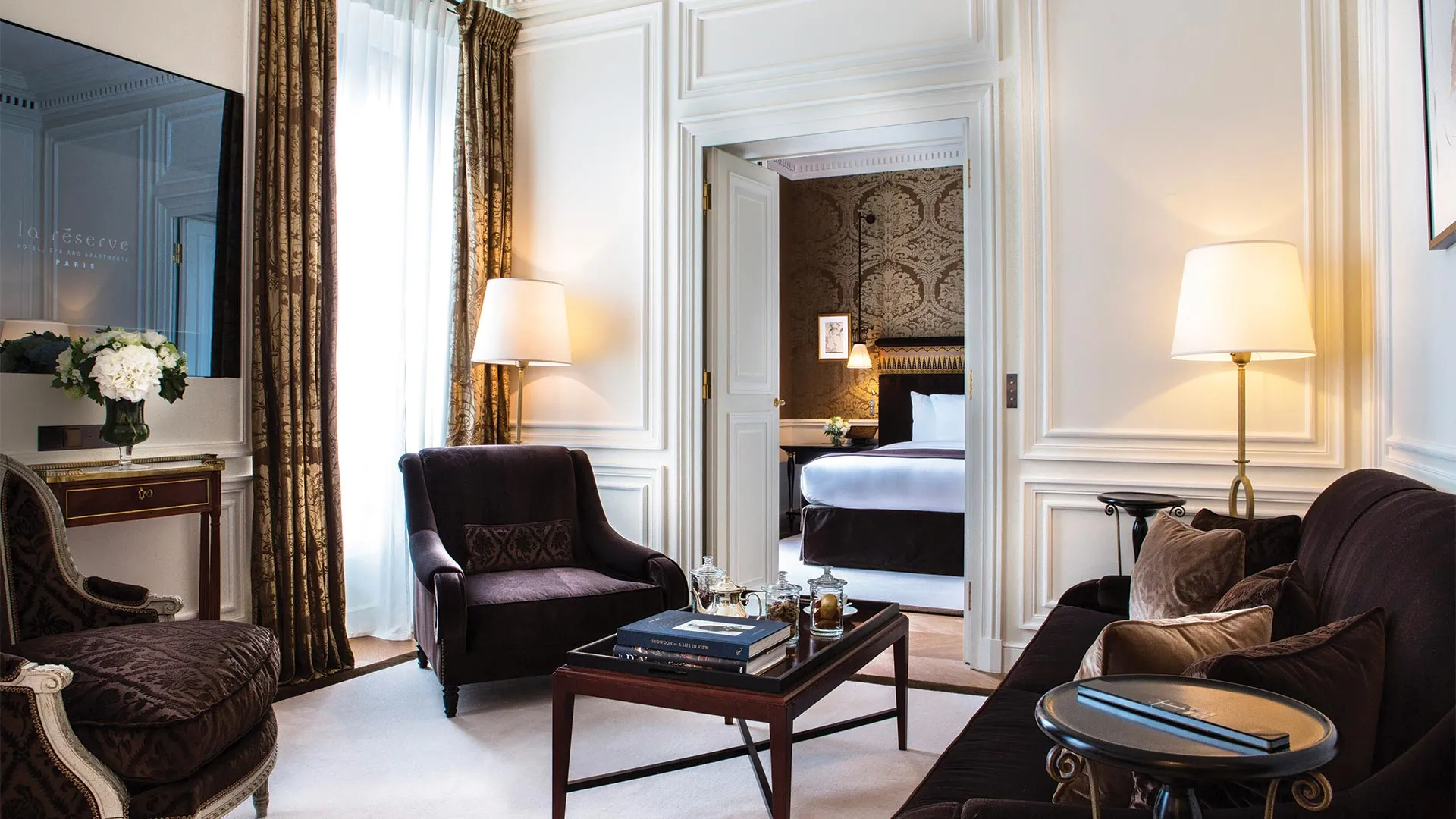 A Jacques Garcia-designed suite interior at La Reserve Paris, with dark wood panelling, gilt detailing and a Belle Epoque colour palette
