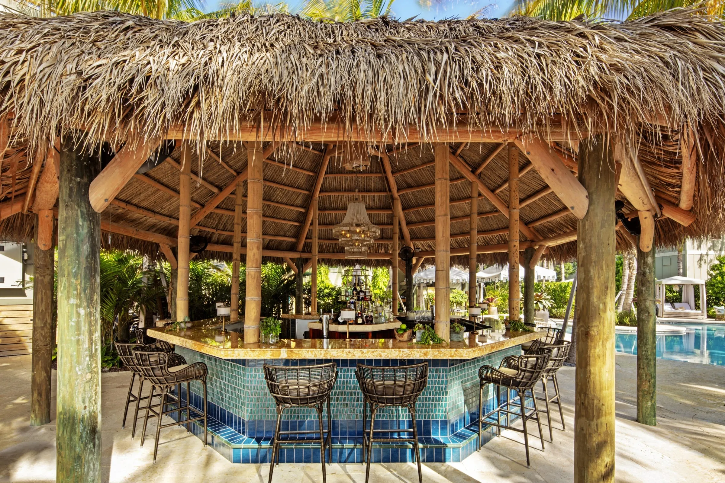 Thatched-roof bungalow suites set among palm trees on the private island of Little Palm Island Resort & Spa in the Florida Keys