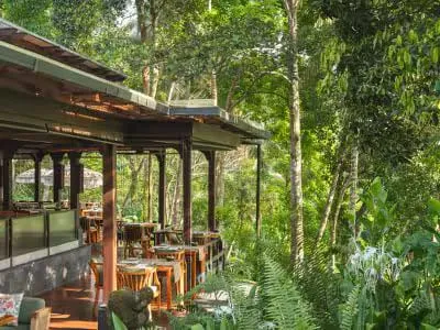 Kubu restaurant's bamboo dining cocoons suspended above the Ayung River at dusk