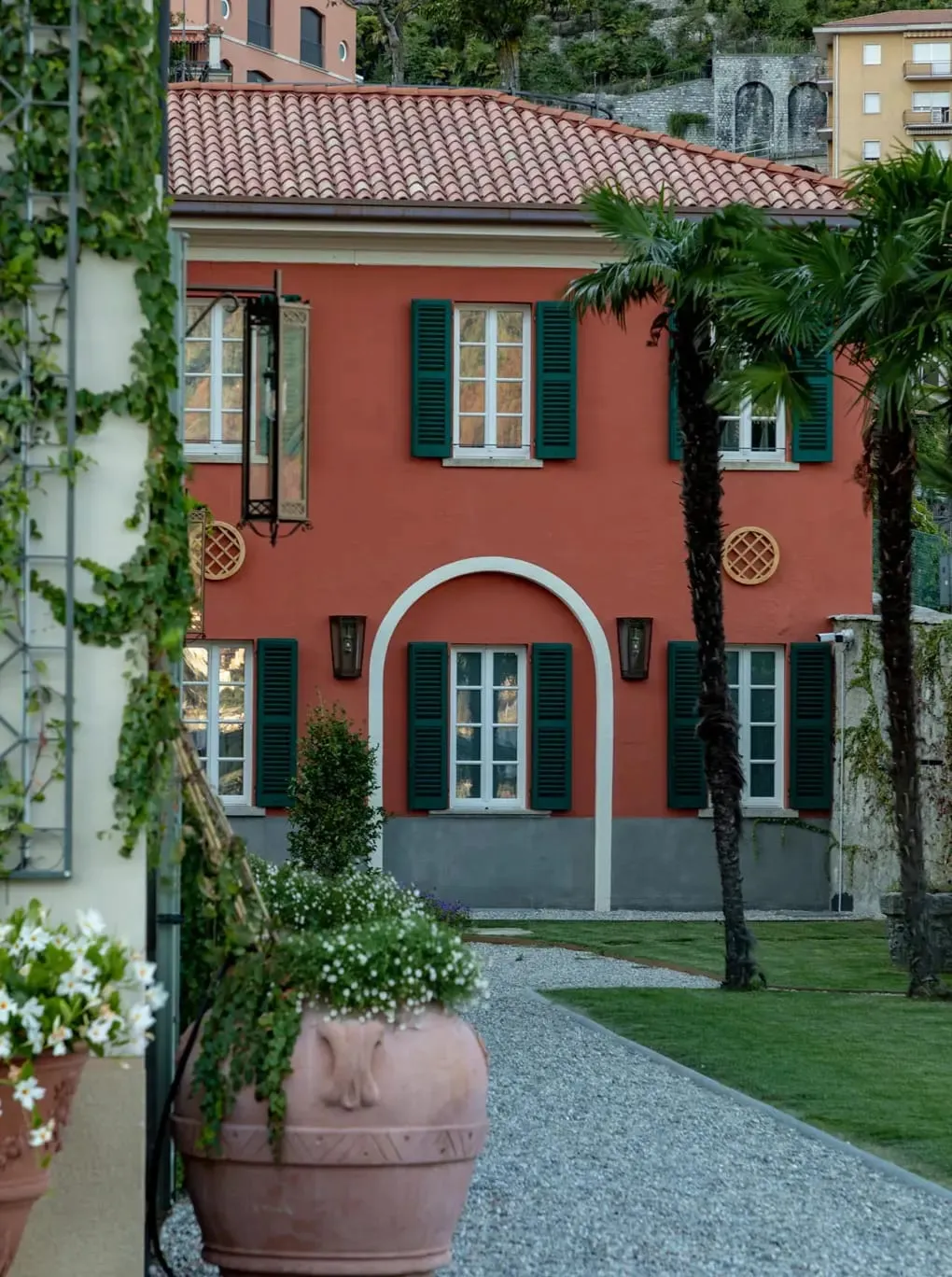 The terraced gardens at Passalacqua descending toward Lake Como with clipped hedges and centuries-old trees