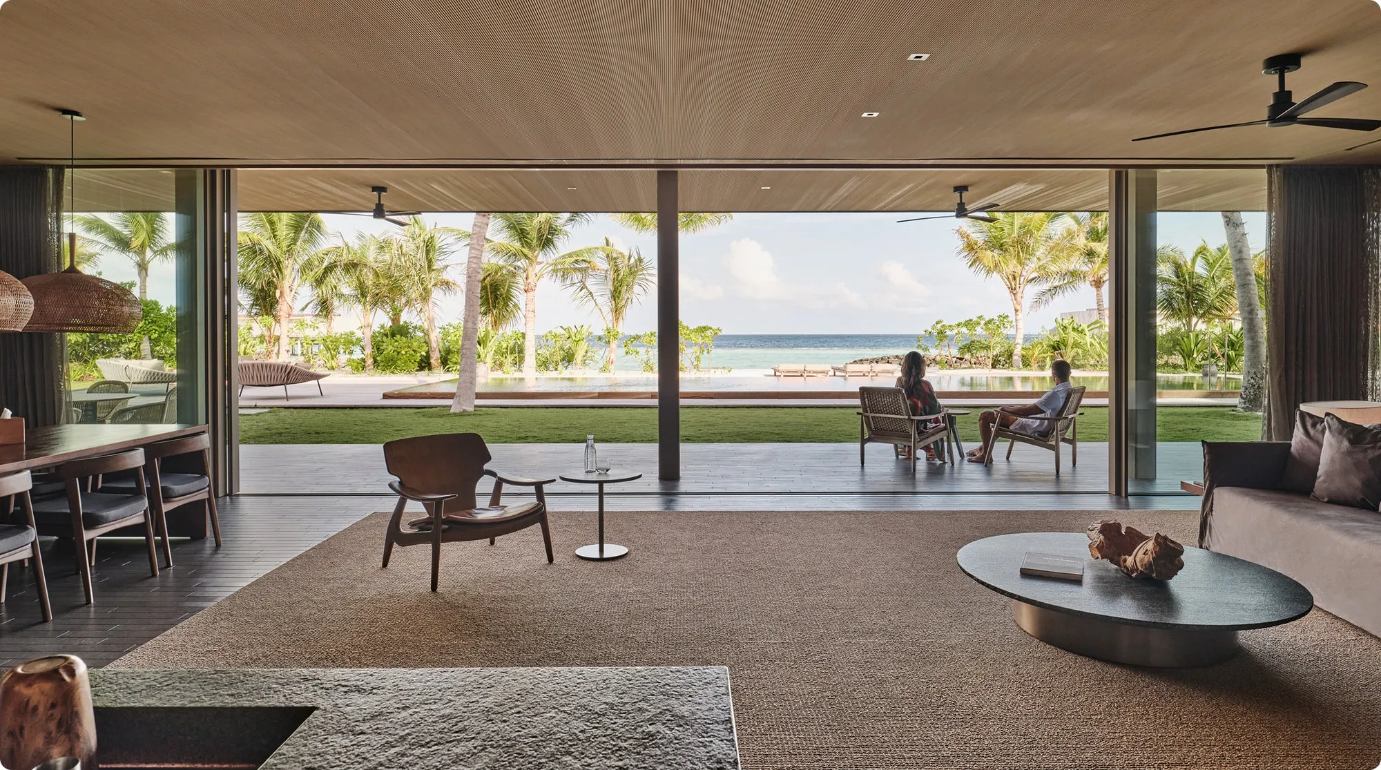 A Studio MK27-designed water villa at Patina Maldives connected by a timber walkway above the lagoon