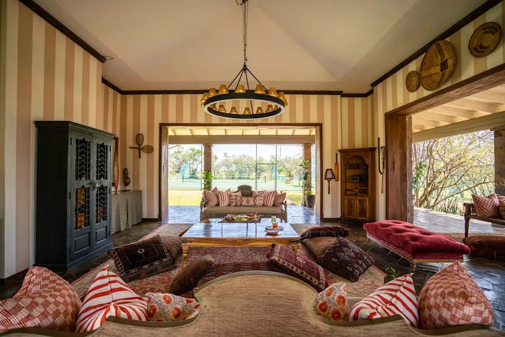 The dining room at Singita Sasakwa Lodge with a marble fireplace and chandelier