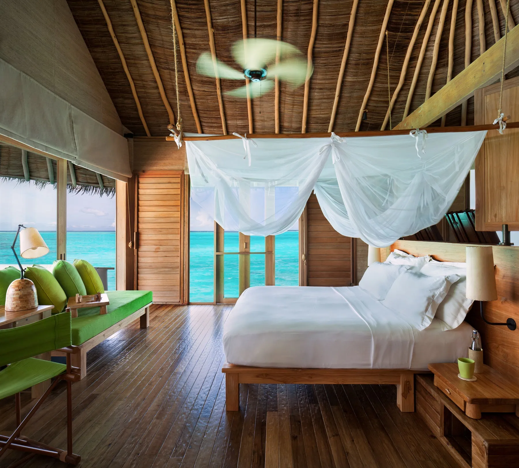 Timber jetty leading to overwater villas at Six Senses Laamu at dusk