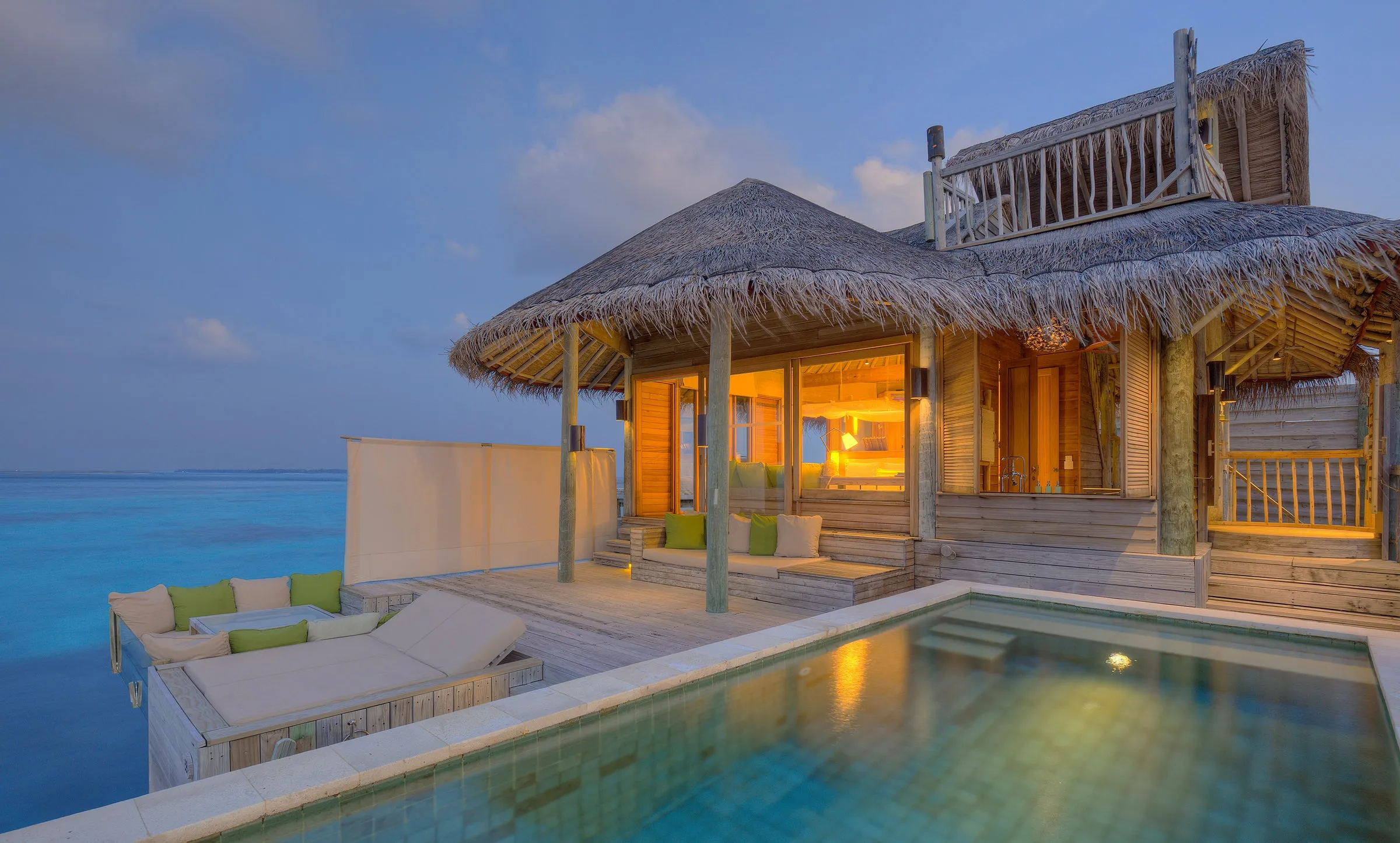 Overwater villas on stilts at Six Senses Laamu extending into the turquoise lagoon off Olhuveli island, Laamu Atoll, Maldives