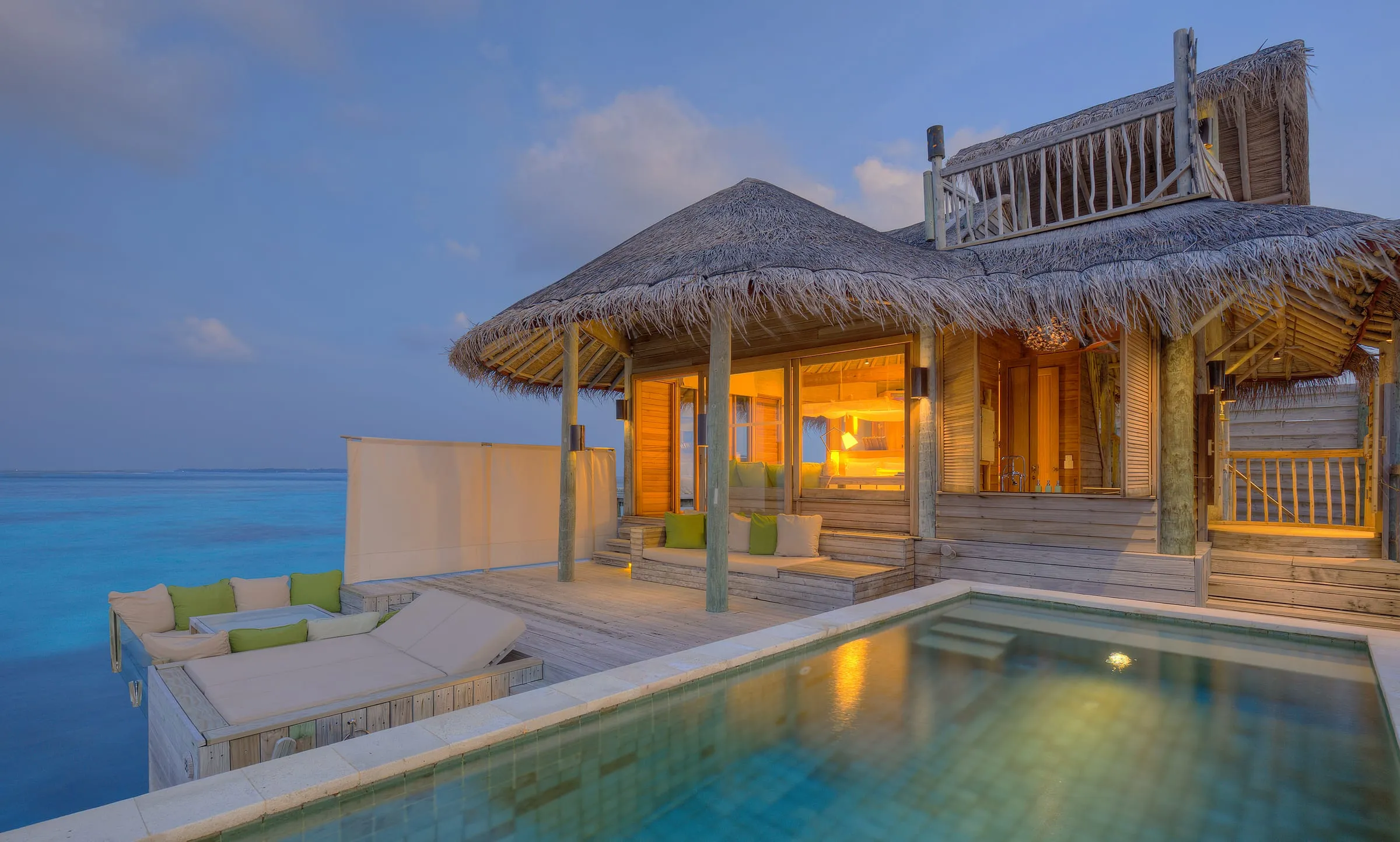 Overwater villas on stilts at Six Senses Laamu extending into the turquoise lagoon off Olhuveli island, Laamu Atoll, Maldives