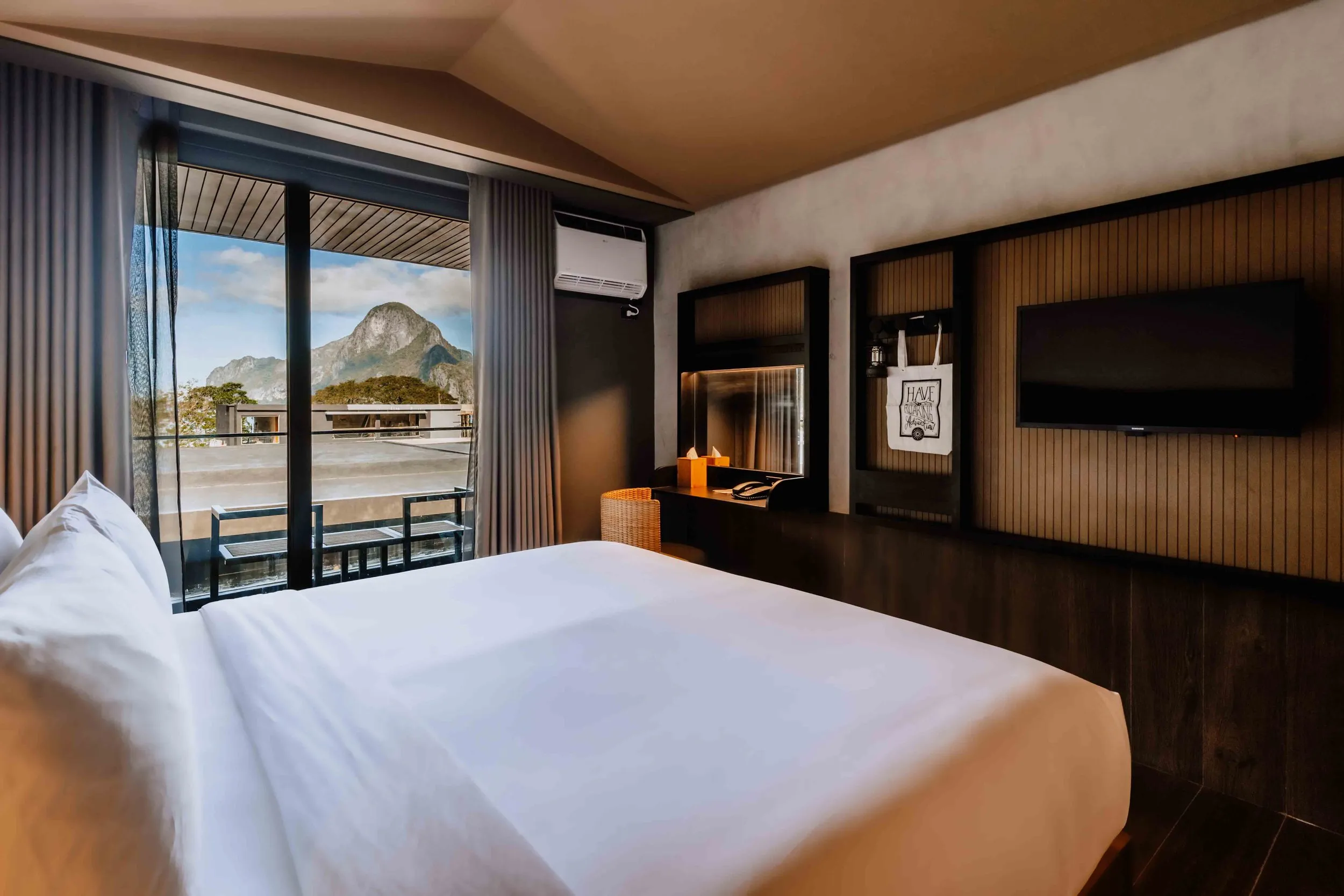 A designer guest room at The Funny Lion with a navy green headboard and rustic timber furniture