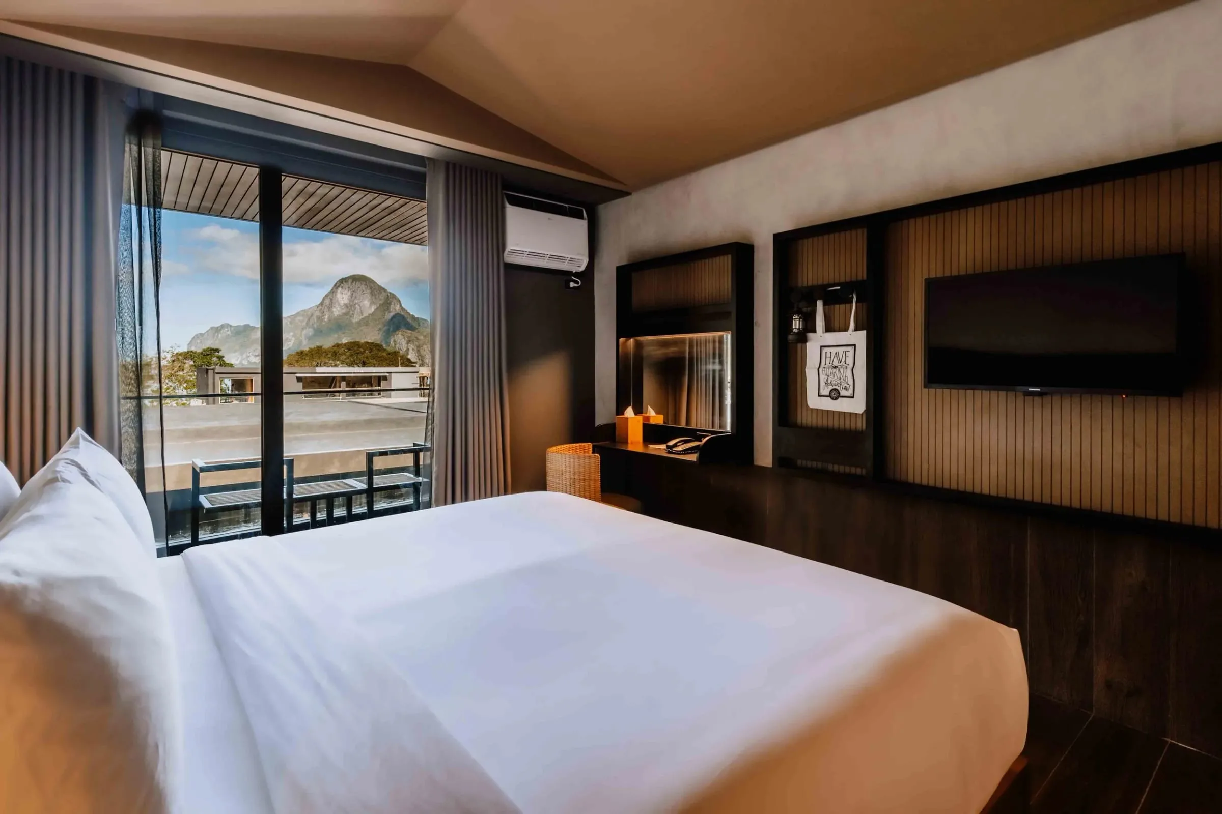 A designer guest room at The Funny Lion with a navy green headboard and rustic timber furniture