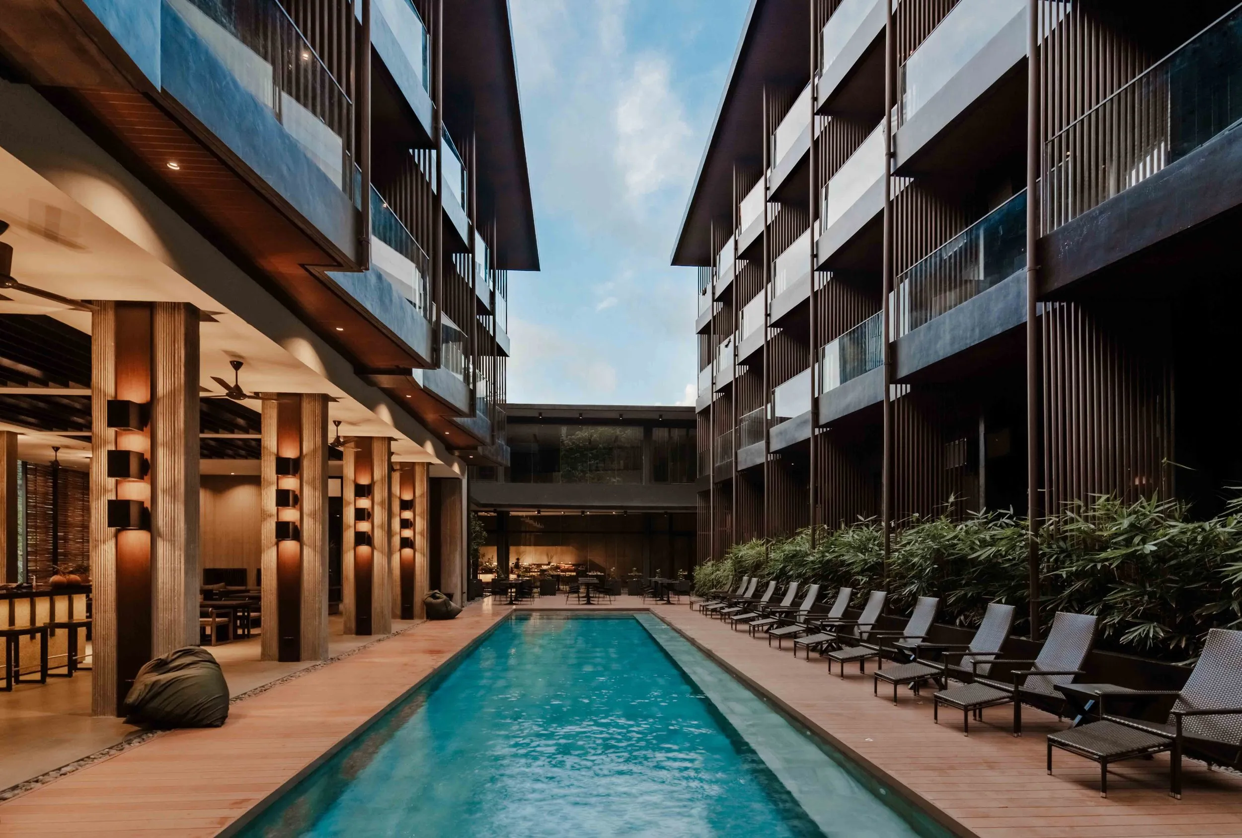 The swimming pool at The Funny Lion El Nido surrounded by rough concrete walkways and greenery