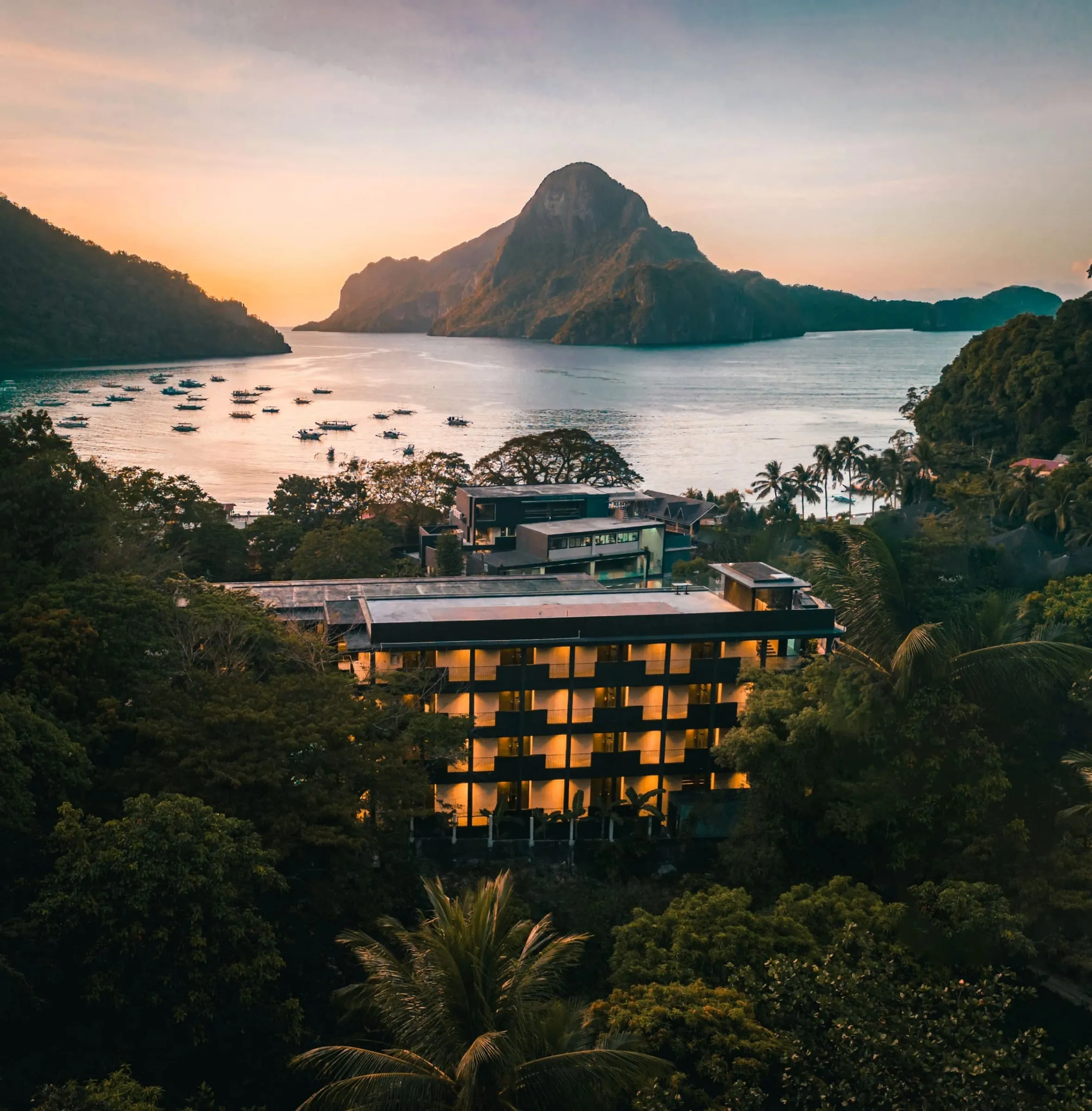 The courtyard pool at The Funny Lion in El Nido town, framed by concrete walkways and bamboo screening