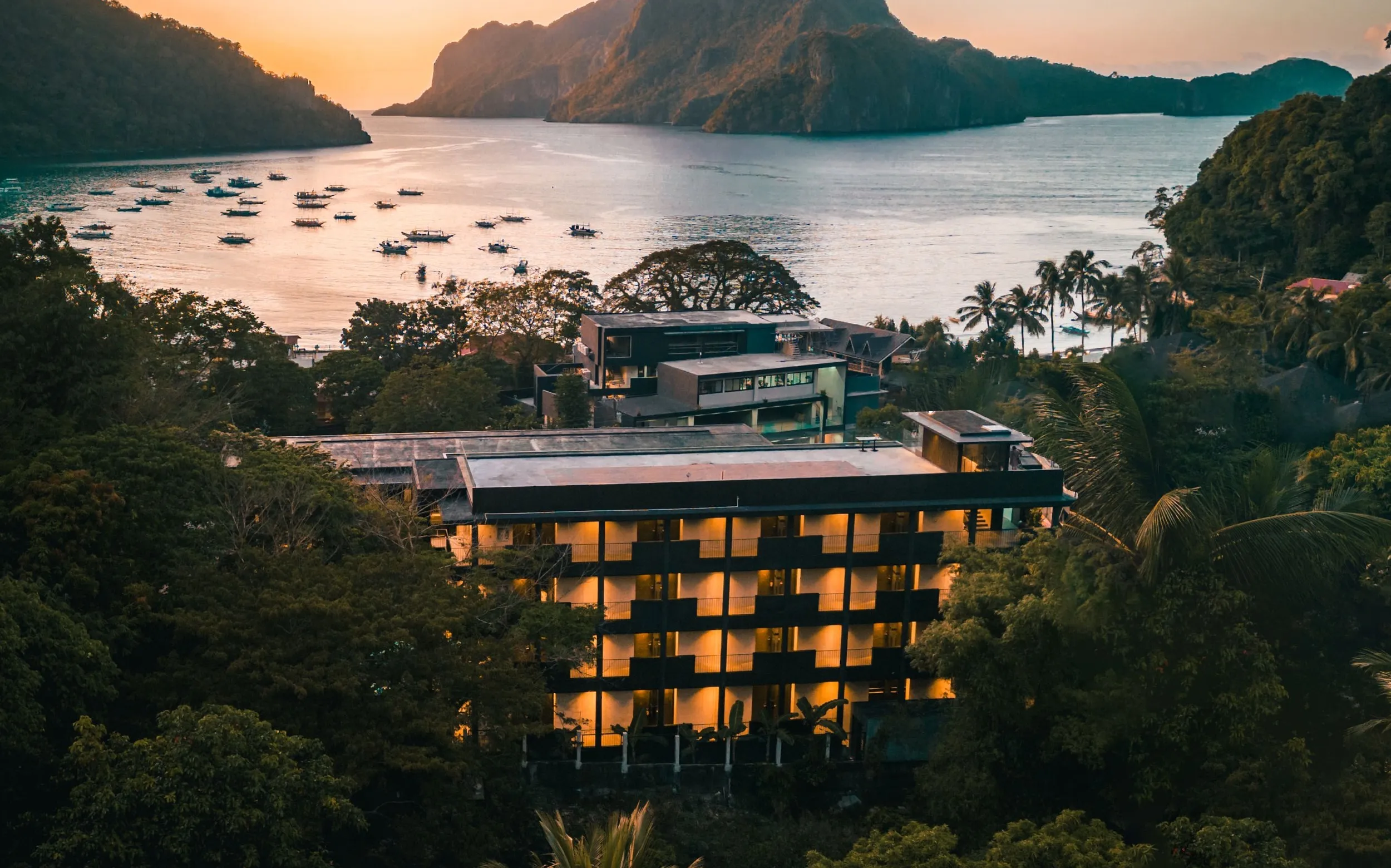 The courtyard pool at The Funny Lion in El Nido town, framed by concrete walkways and bamboo screening