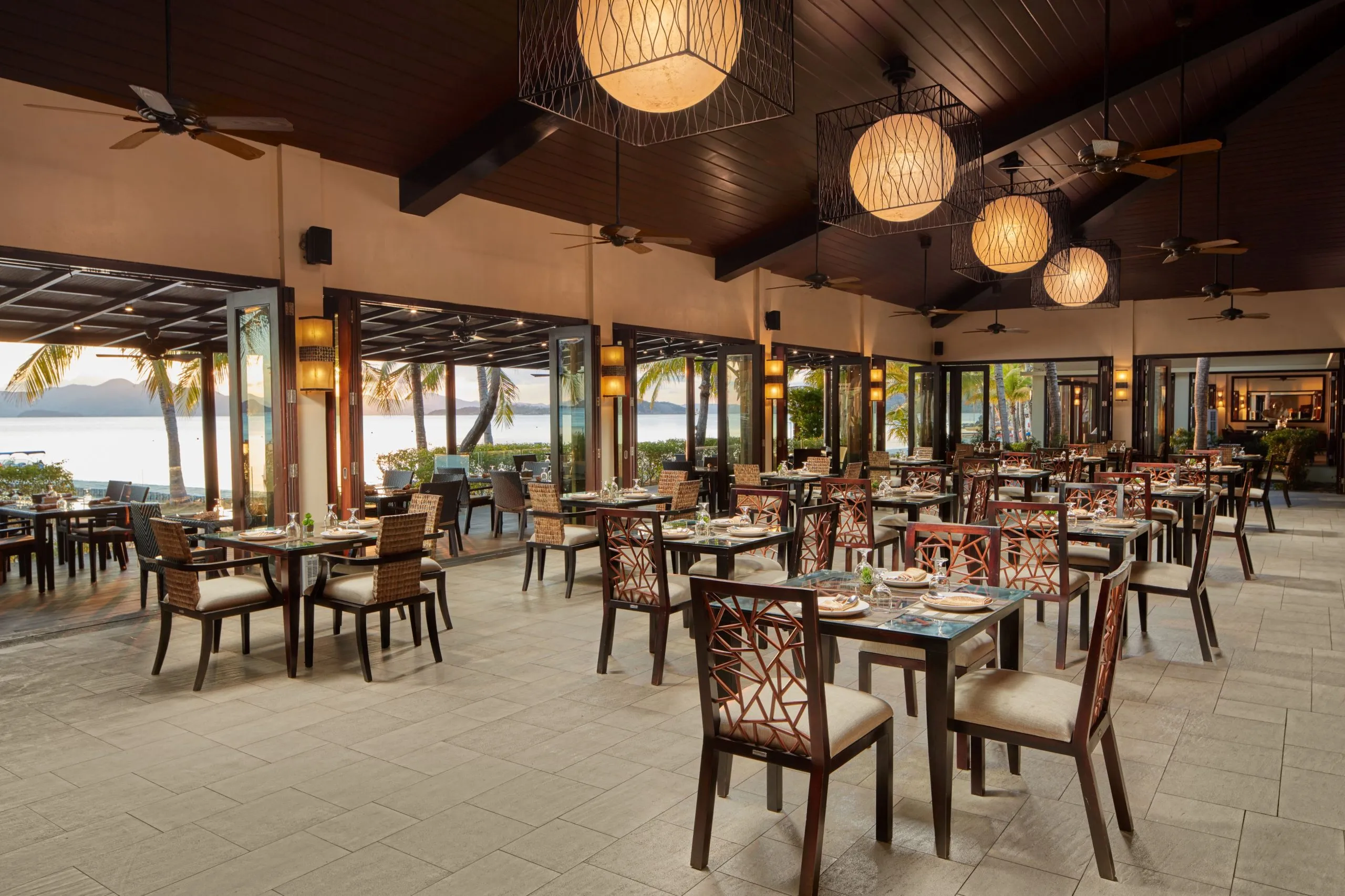 Tables set at Sulu Restaurant overlooking the sea at Two Seasons Coron Island Resort