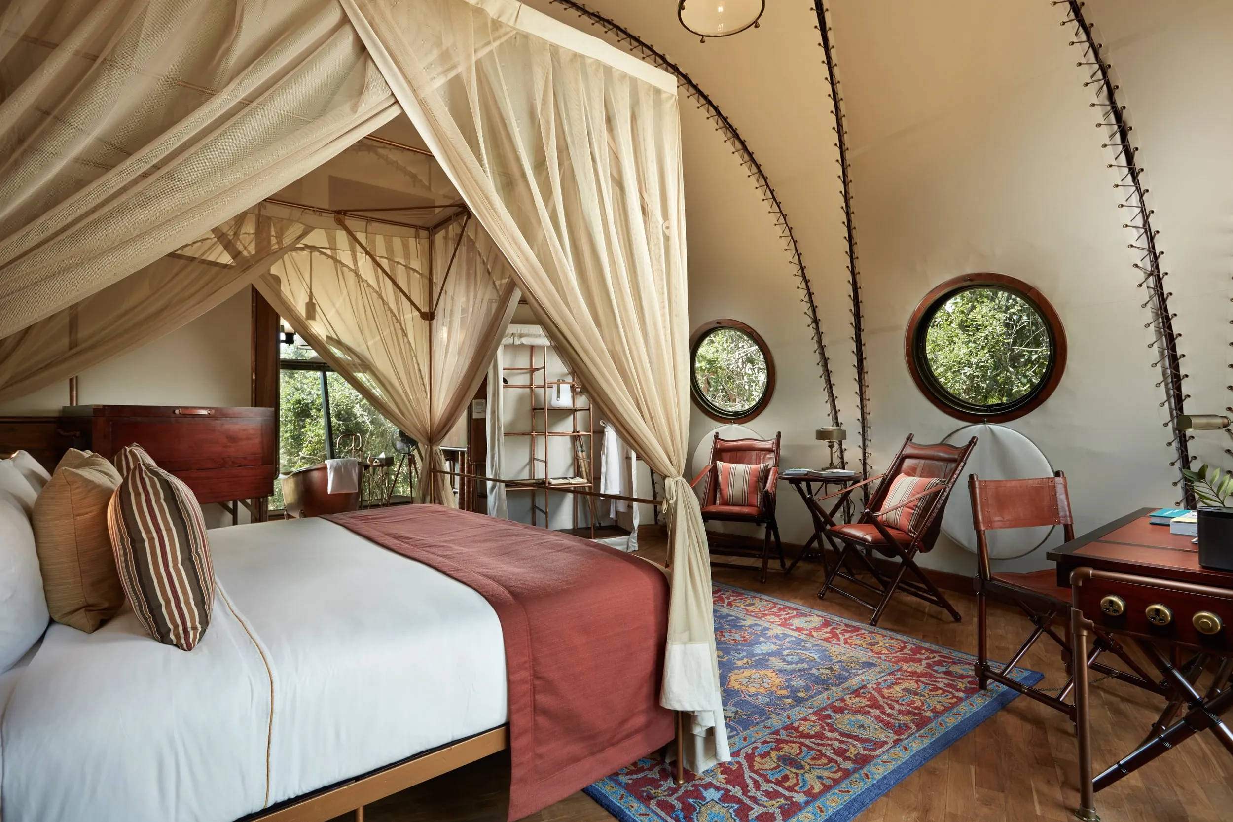 Interior of a Cocoon Suite with vaulted canvas ceiling, campaign furniture and copper bathtub